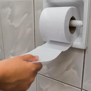 A hand holding toilet paper