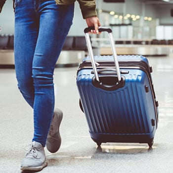 A person walking with their suitcase in airport