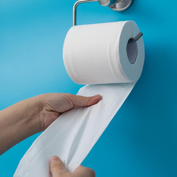 Hands pulling out toilet paper